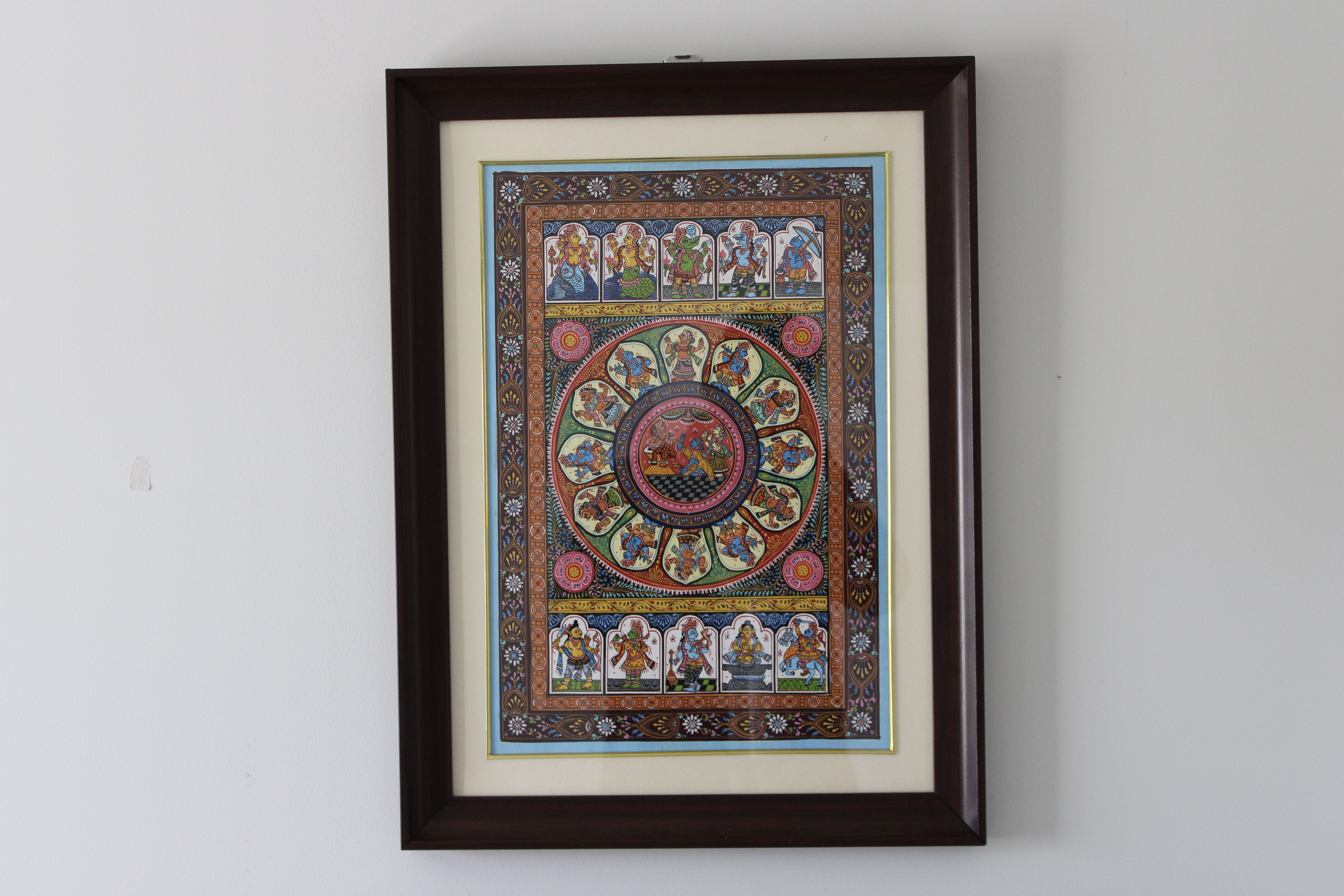 Framed Pattachitra artwork photographed on a light wall